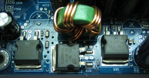 Três MOSFETs e uma bobina, formando um dos estágios do regulador de tensão