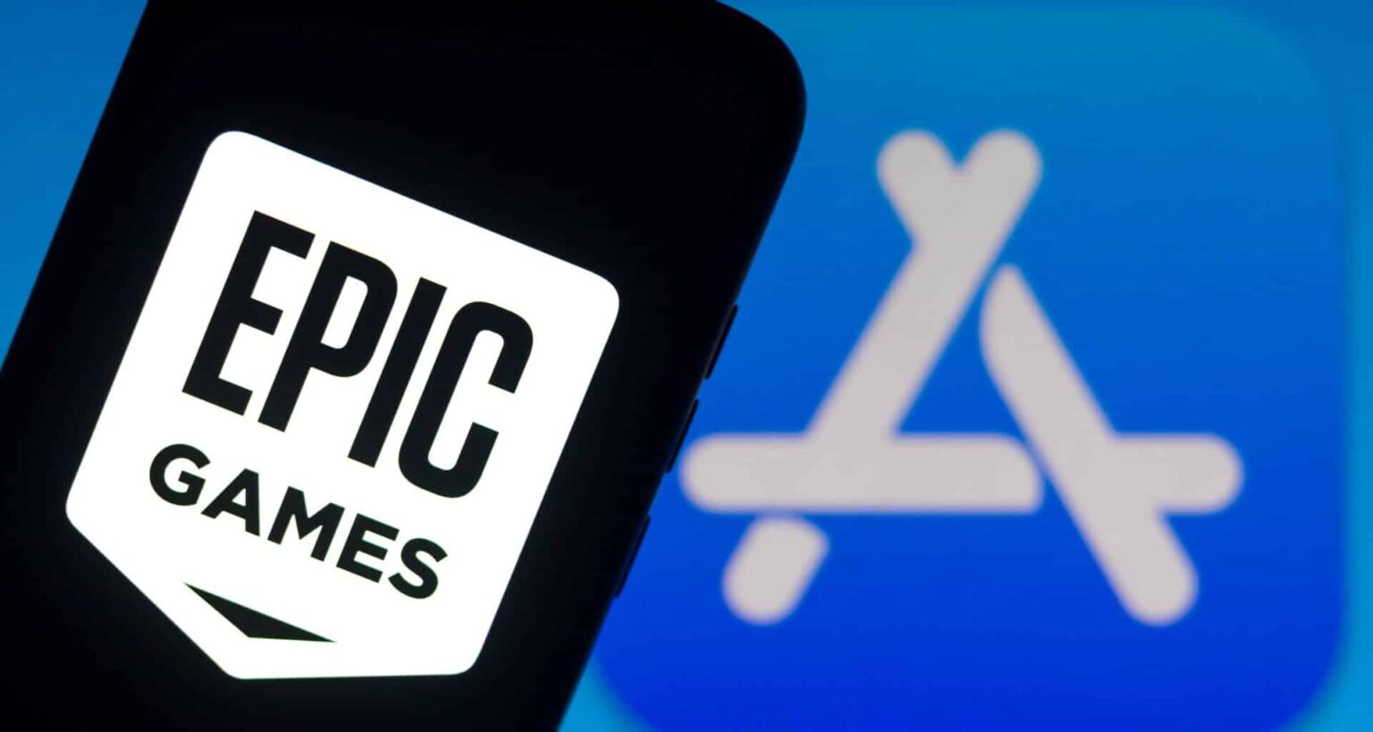 Smartphone exibindo o logo da Epic Games em primeiro plano, com o logo da App Store da Apple desfocado ao fundo em tons de azul