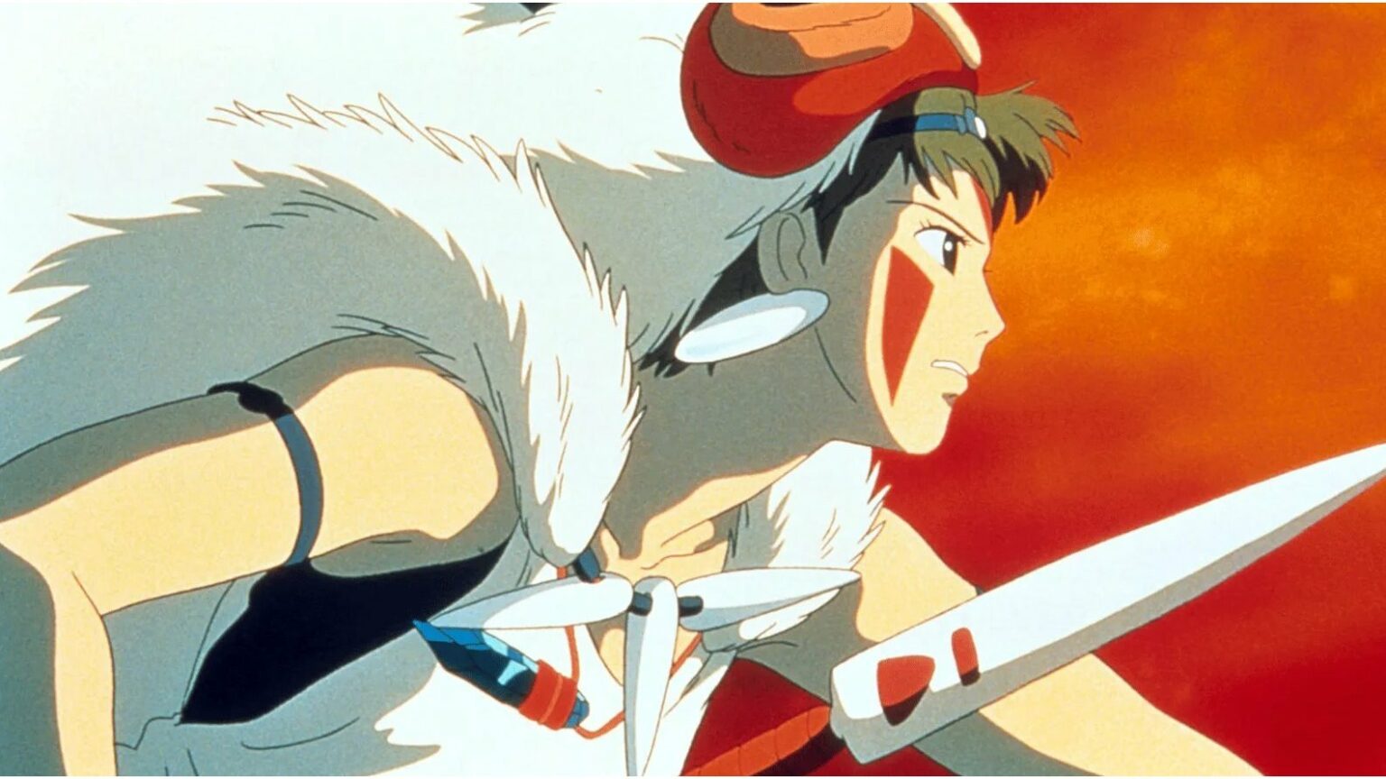 Personagem de anime com capa de pele branca e máscara vermelha, empunhando uma lança em frente a um céu alaranjado, em cena de Princesa Mononoke