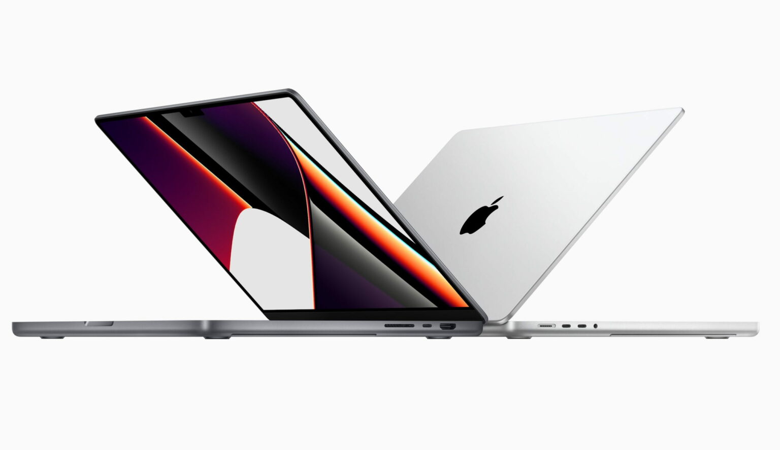Dois notebooks Apple MacBook Pro, um cinza espacial aberto e outro prateado fechado, lado a lado sobre fundo branco