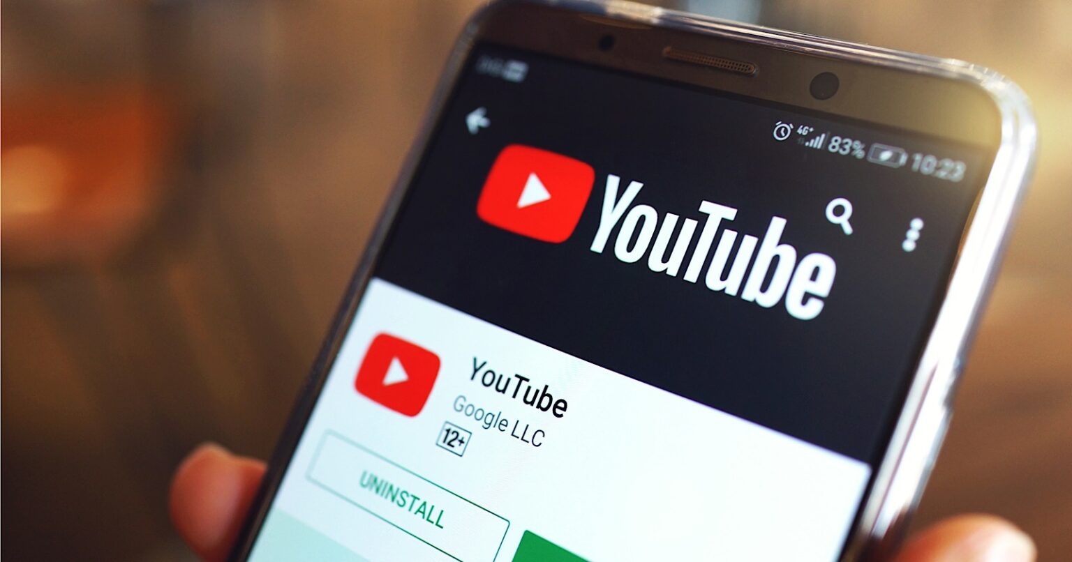 Smartphone exibindo a página do aplicativo YouTube na Google Play Store, com a opção Desinstalar visível e a classificação 12+