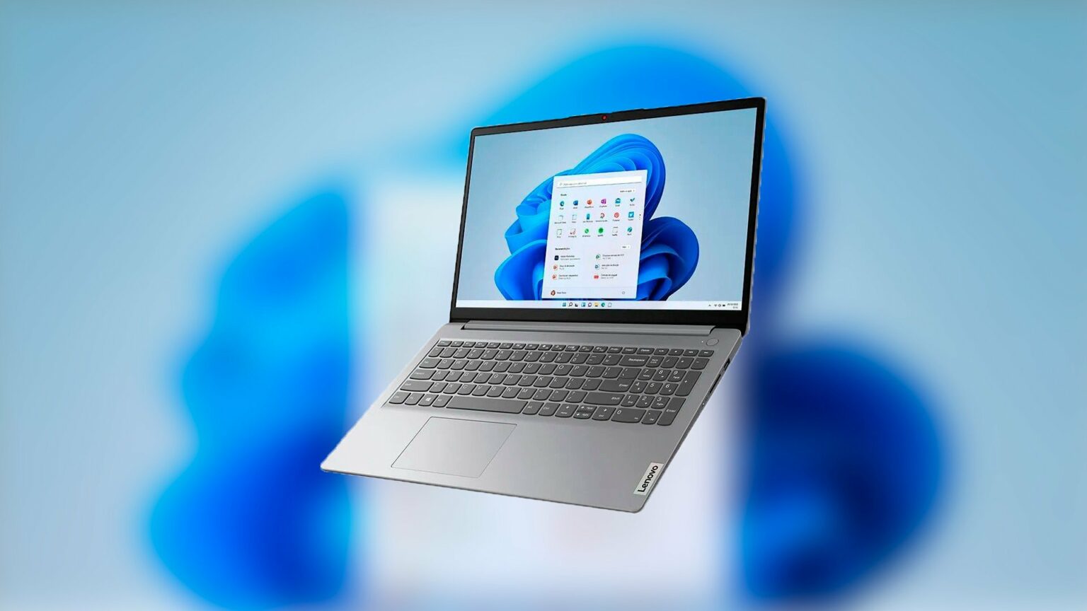 Notebook Lenovo cinza com tela exibindo o Windows 11 sobre fundo azul com o logo da Microsoft desfocado