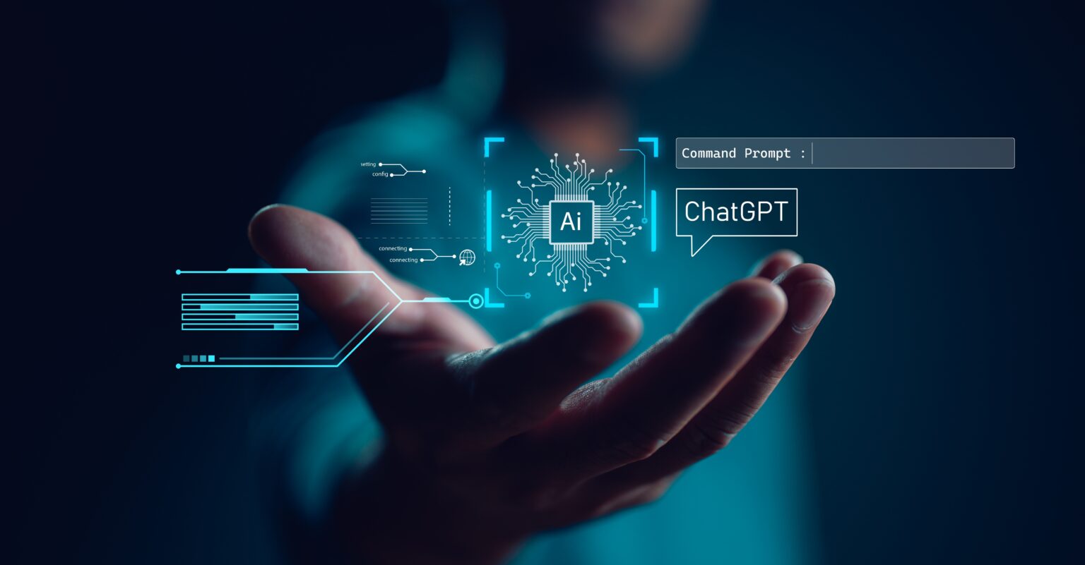 Mão em primeiro plano segurando um holograma azul com um chip de IA, um campo "Command Prompt" e um balão com a palavra ChatGPT