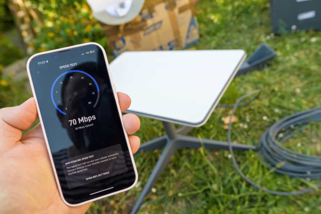 Project Kuiper supera Starlink: Amazon atinge 1.289 Mbps em teste recorde 2 Smartphone branco mostrando teste de velocidade de internet com 70 Mbps de download e 30 Mbps de upload ao ar livre