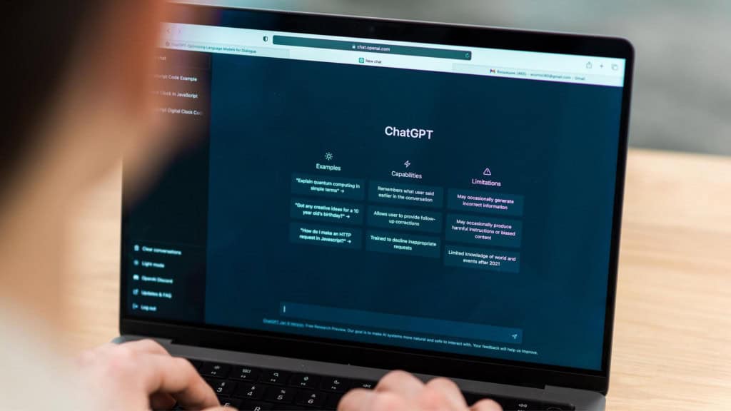 Pesquisadores descobrem que modelos de IA podem te enganar e manipular intencionalmente 2 Mãos interagindo com smartphone exibindo interface de chat do ChatGPT com avisos sobre limitações e conteúdo