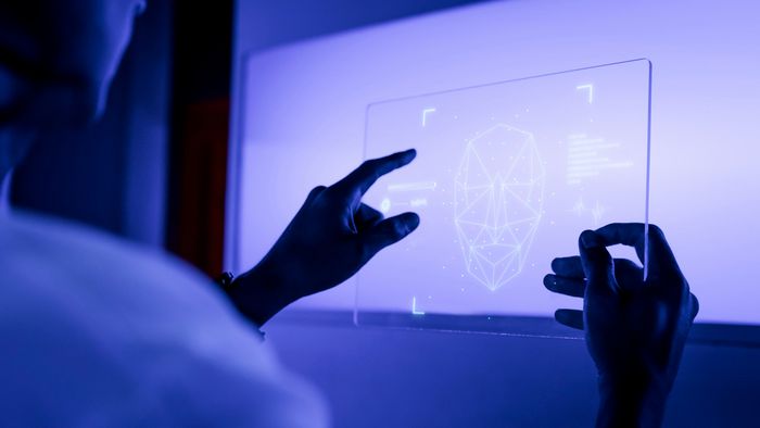 Usar o ChatGPT pode aumentar a desonestidade sem que você perceba 1 Mãos manipulando interface tecnológica holográfica com modelo 3D de cabeça em wireframe azul