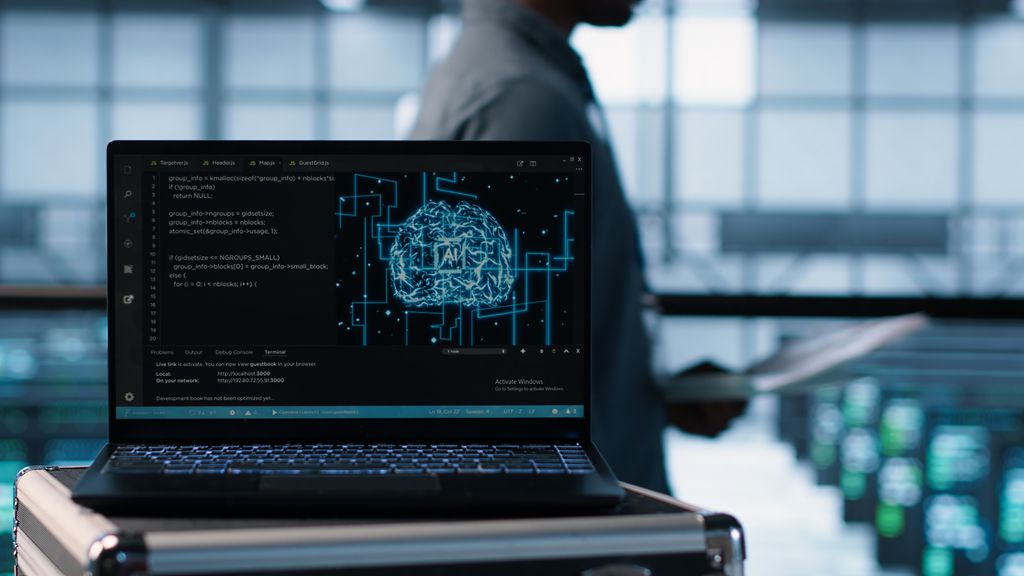 Usar o ChatGPT pode aumentar a desonestidade sem que você perceba 2 Laptop mostrando código de programação e ilustração holográfica de cérebro azul com circuitos