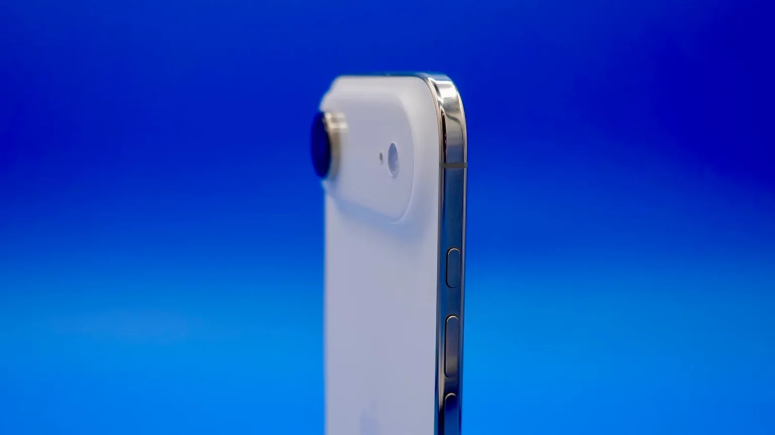 Smartphone branco de perfil, com câmera traseira e botões laterais de metal, sobre fundo azul degradê