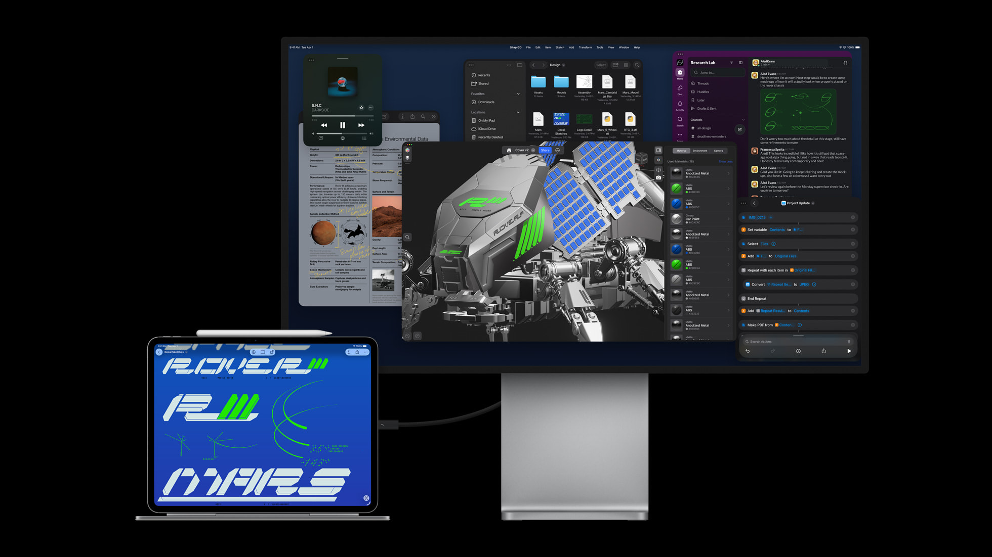 iPad Pro conectado a um monitor Apple Studio Display, ambos exibindo a interface do iPadOS com janelas de apps de trabalho e um modelo 3D de rover espacial na…