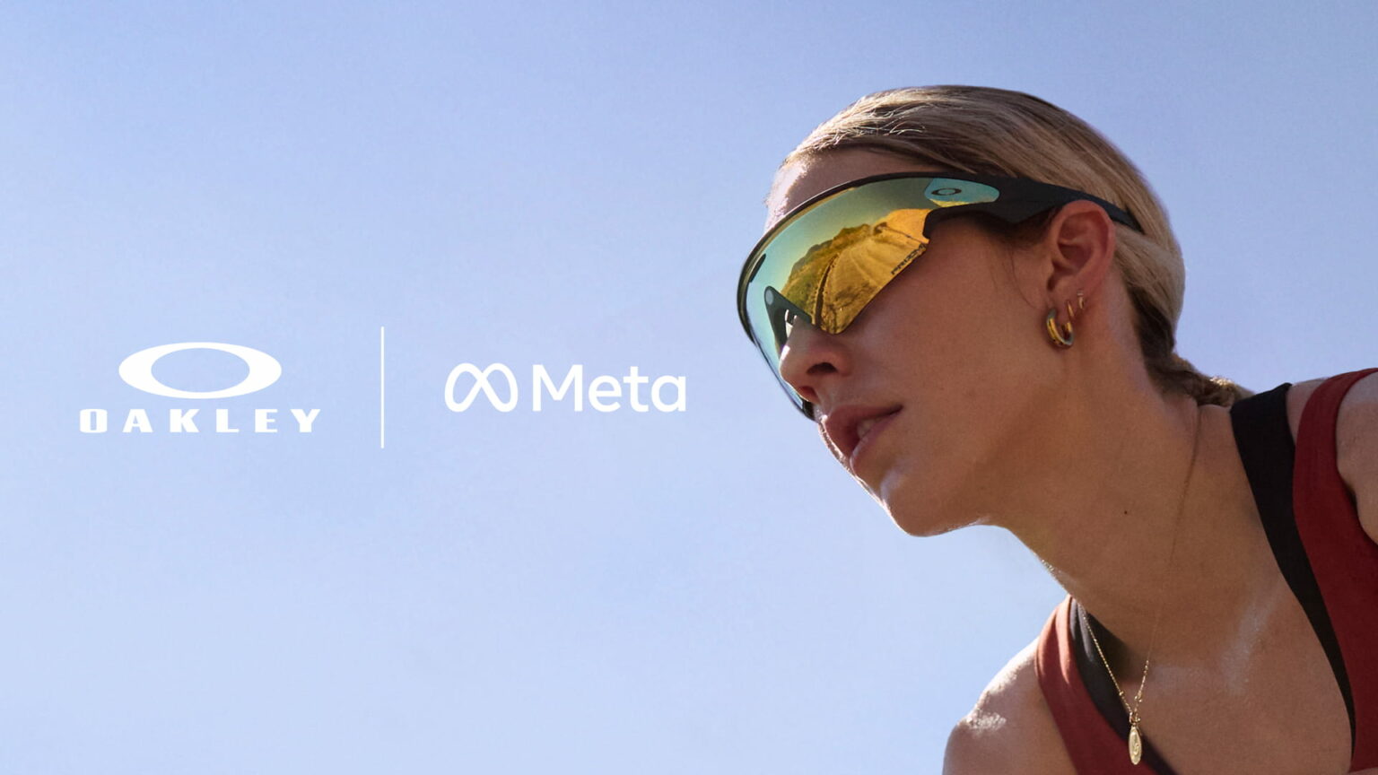 Mulher de óculos esportivos Oakley com lente espelhada amarela, ao lado das logos Oakley e Meta sobre fundo de céu azul