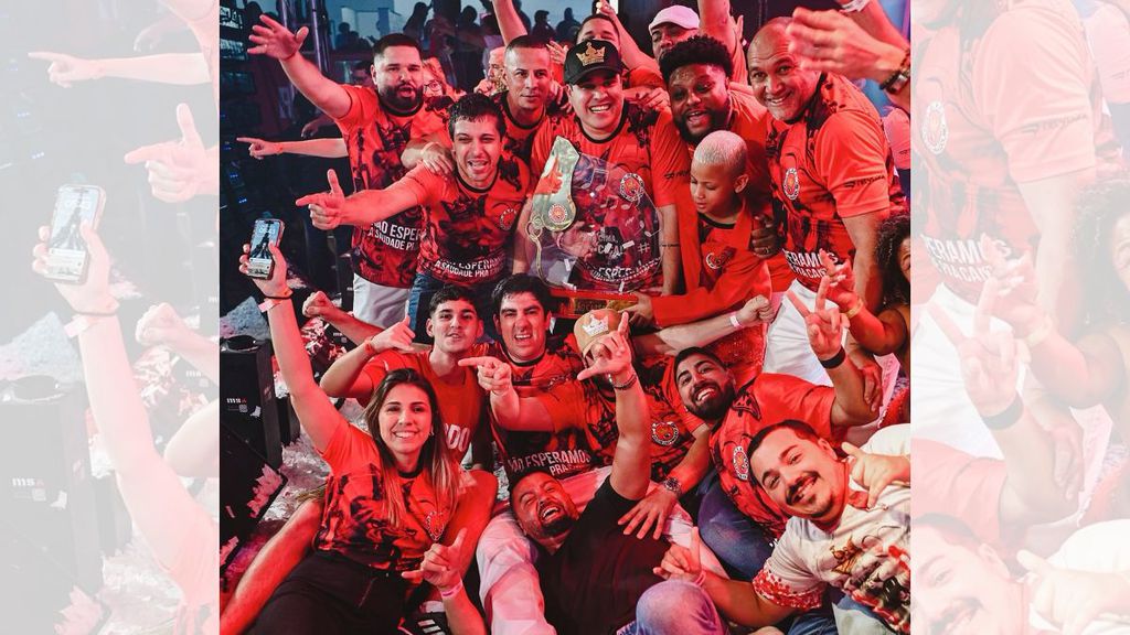 Unidos do Viradouro usa IA para trazer de volta a voz de Dominguinhos do Estácio 2 Comemoração de equipe da Unidos do Viradouro segurando troféu dourado comemorando vitória em ambiente interno