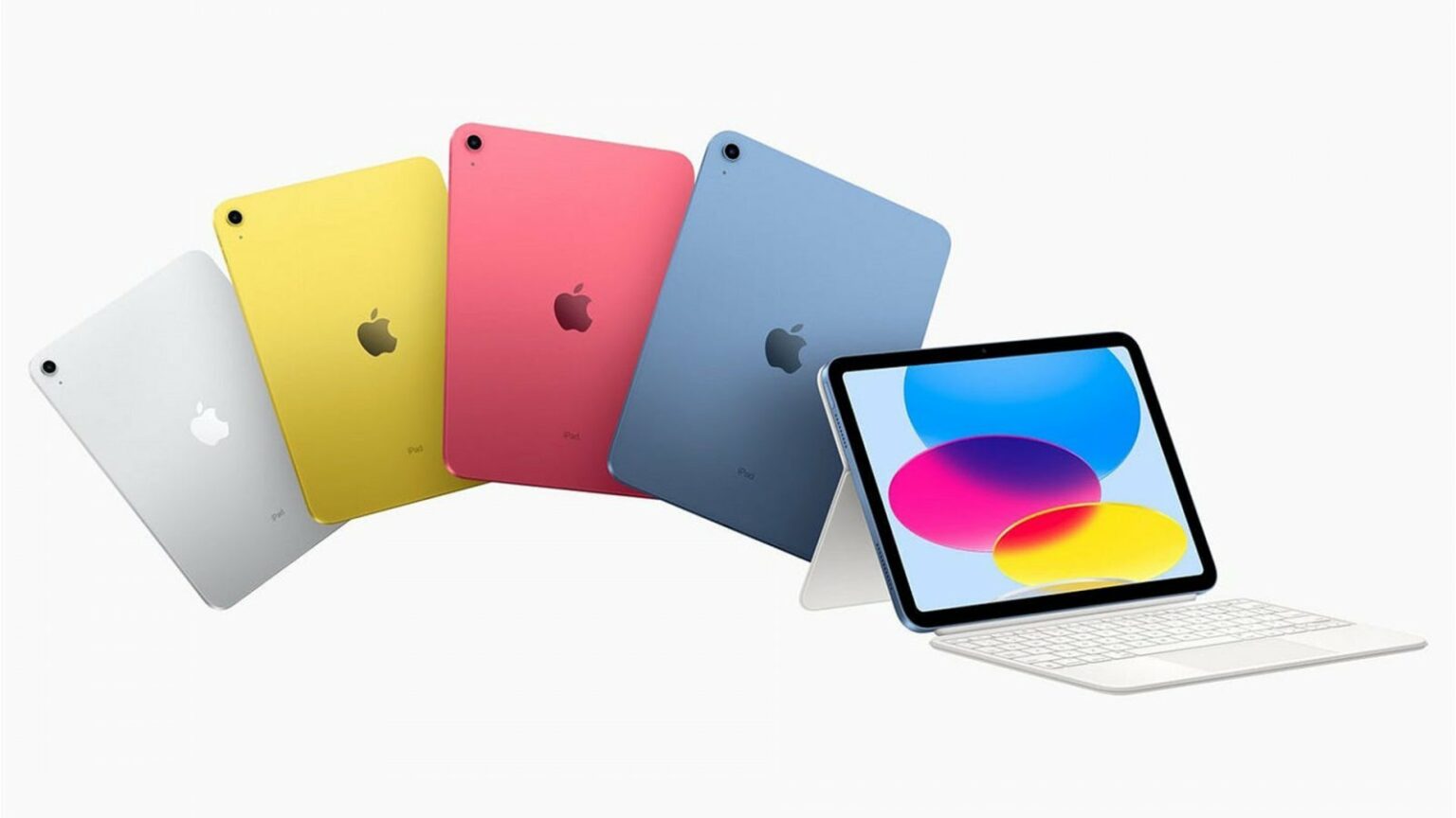 Quatro iPads de cores diferentes (prata, amarelo, rosa e azul) dispostos em leque, com um iPad azul à frente conectado a um teclado branco