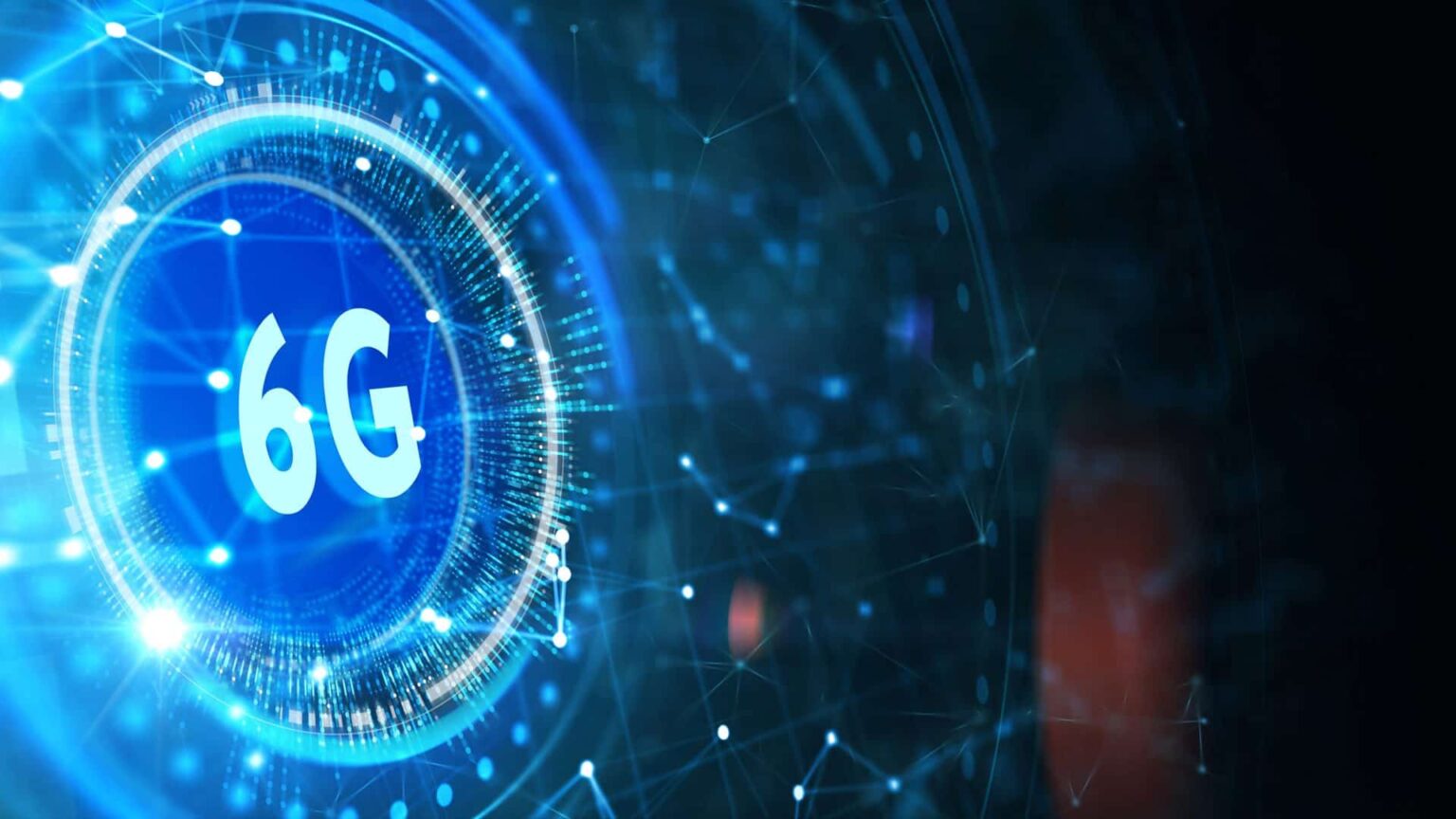 Ilustração digital de um círculo azul brilhante com o texto "6G" em destaque, cercado por conexões de rede e pontos luminosos sobre fundo escuro