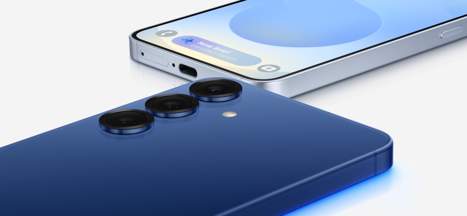 Smartphone Samsung Galaxy S25+ azul com três lentes traseiras em destaque, vista de ângulo com a tela frontal ao fundo