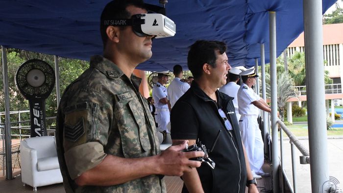 Escola de drones da Marinha do Brasil: um novo marco para 2026 2 Homem com uniforme camuflado usando óculos de realidade virtual segurando controle em evento de demonstração tecnológica da Marinha do Brasil