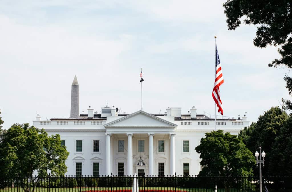 NVIDIA desenvolve sistema para rastrear localização de chips de IA e combater contrabando 2 Fachada da Casa Branca em Washington com bandeira dos EUA tremulando ao vento