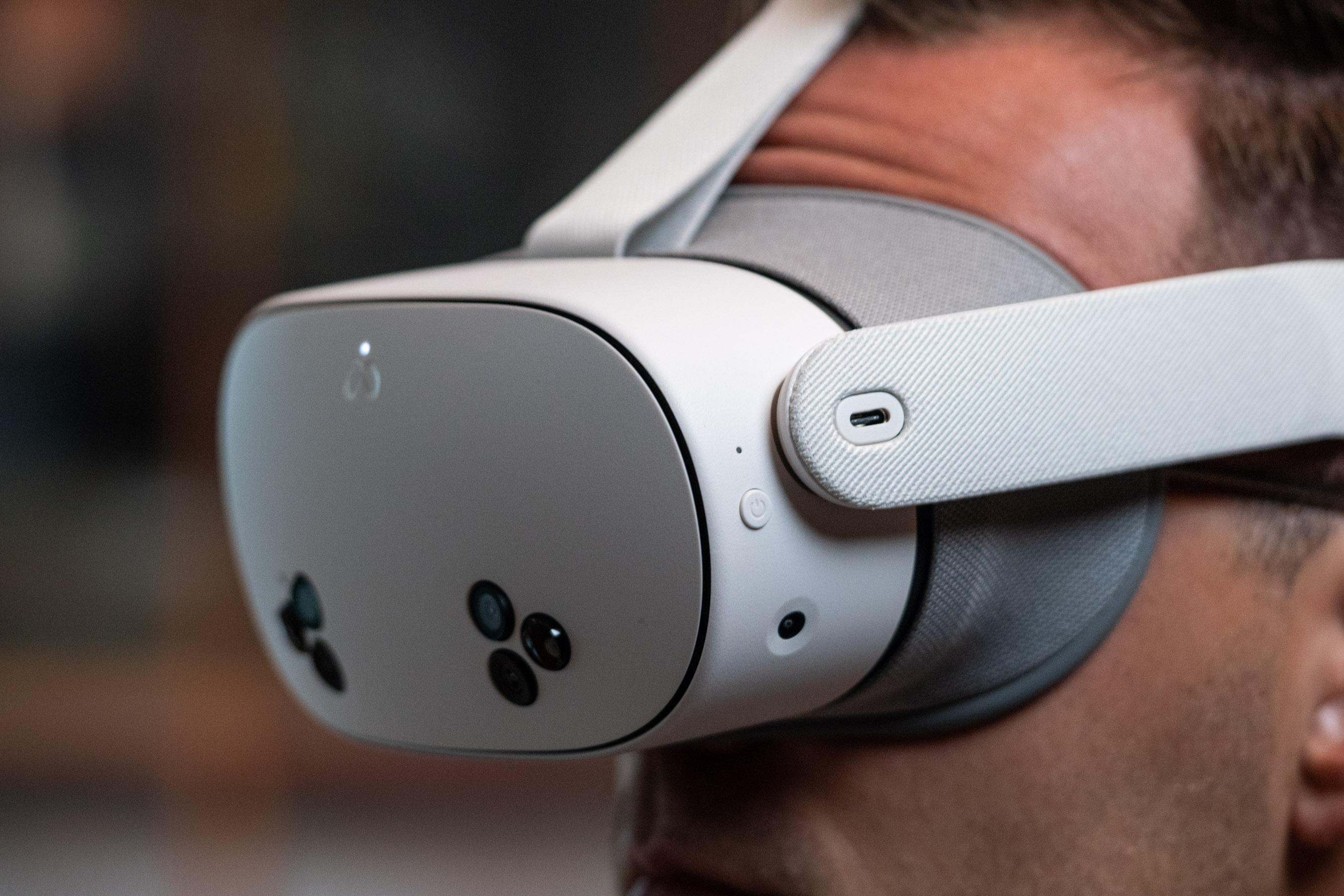 Pessoa de perfil usando headset de realidade virtual Meta Quest 3 com sensores frontais visíveis