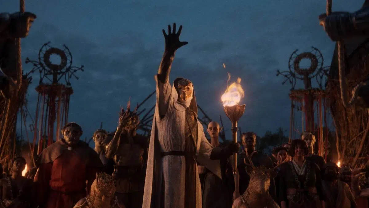 Larian Studios decide não usar mais IA generativa nas artes conceituais de Divinity 1 Ritual noturno com figura central de manto branco e máscara segurando tocha durante cerimônia em Divinity