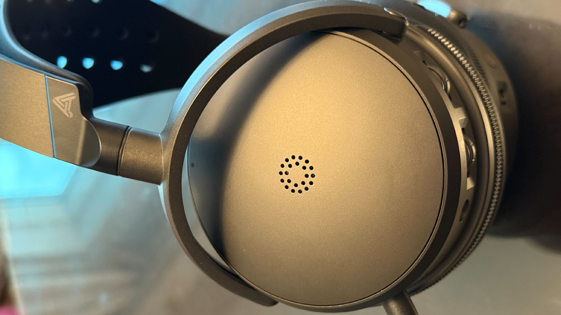 O Audeze Maxwell 2 redefine o áudio para gamers com tecnologia SLAM 2 Close-up de headset over-ear Audeze Maxwell 2 destacando concha grafite fosca com detalhes metálicos e logotipo triangular
