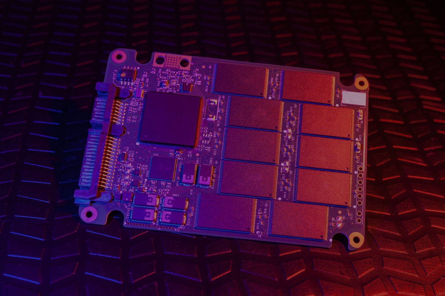 Placa de SSD sem invólucro, com controladora e chips de memória NAND 3D sob luz roxa e avermelhada, sobre fundo texturizado