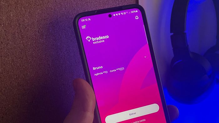 Bradesco anuncia Pix parcelado sem usar o limite do cartão de crédito 1 Smartphone mostrando aplicativo Bradesco Exclusive na tela de login com tema roxo-púrpura