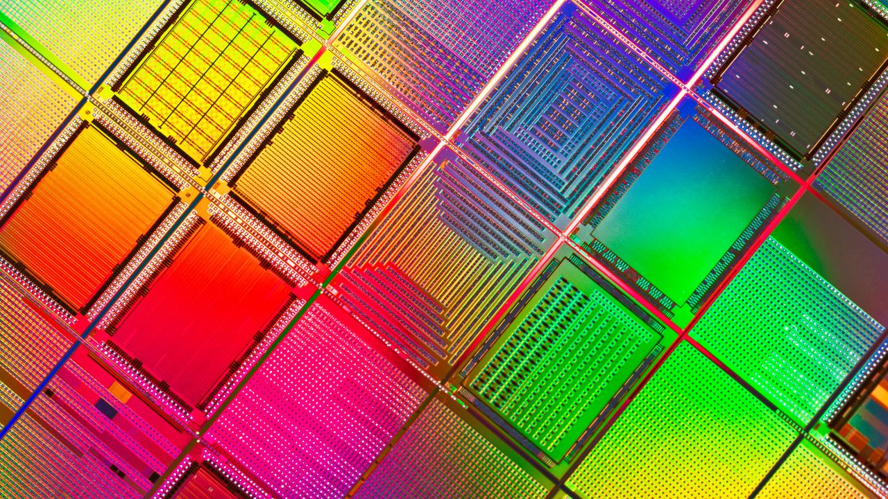 Macro extremo de wafer de semicondutores colorido mostrando a microarquitetura de circuitos e transistores ópticos em alta densidade