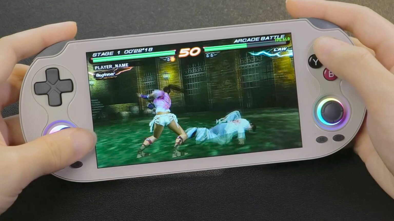 Portátil Anbernic RG Vita com jogo de luta Tekken em tela de 50 pontos de combate, mostrado nas mãos de um usuário