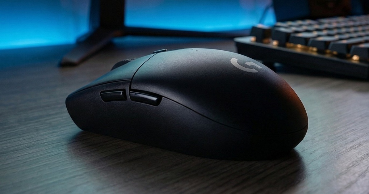 Mouse gamer preto sem fio Logitech sobre mesa escura, com logo G em destaque e teclado iluminado ao fundo