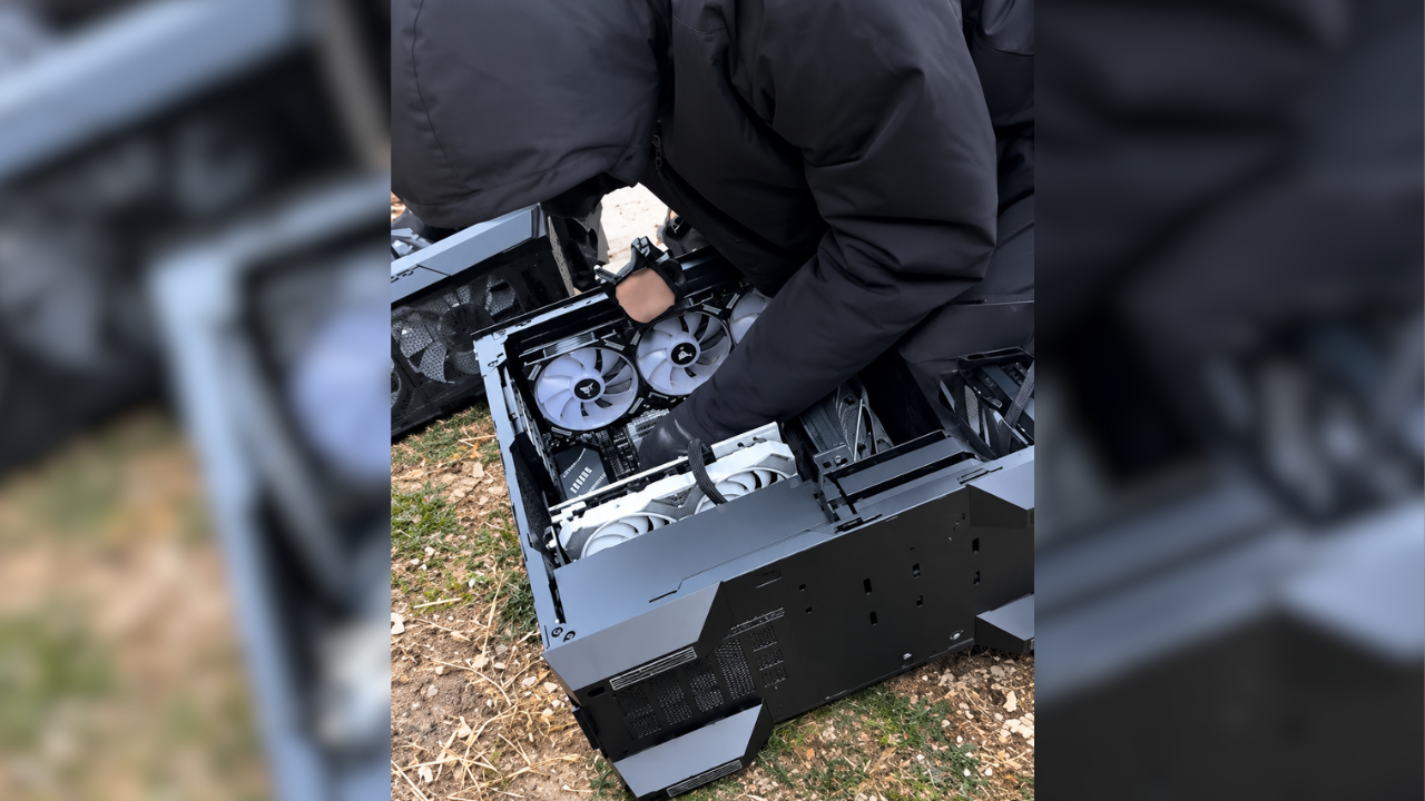 Pessoa de jaqueta preta retirando componentes de um PC gamer com ventoinhas brancas, com o gabinete aberto sobre a grama