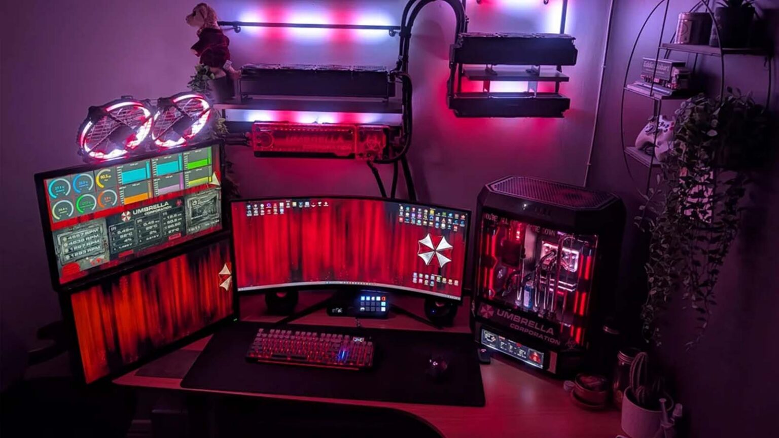 Setup gamer com temática Umbrella Corp, com monitores vermelhos exibindo o logotipo da Umbrella, teclado iluminado, PC com gabinete de vidro e iluminação LED v…