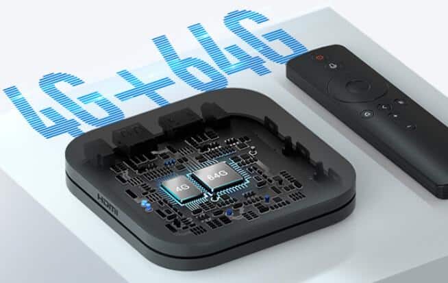 Caixa Xiaomi TV Box com a tampa aberta mostrando os chips de 4 GB e 64 GB ao lado do controle remoto, com texto "4G+64G" em destaque