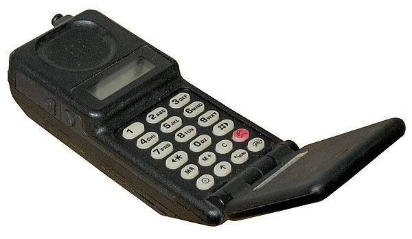 Celular antigo preto do tipo flip, com teclado numérico, visor de cristal líquido e antena, de design típico dos anos 90