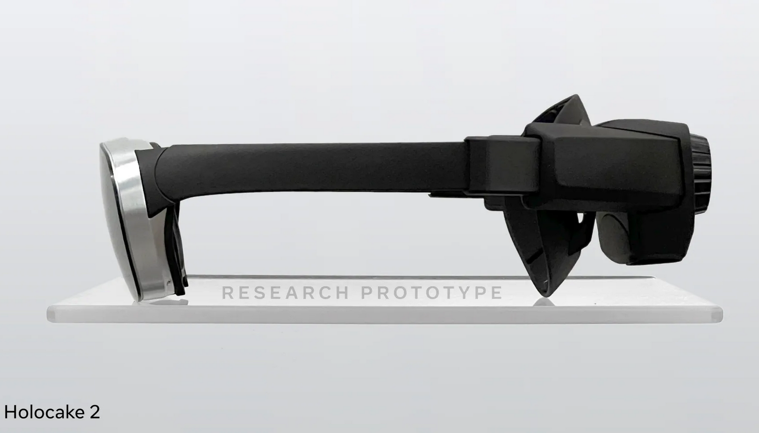 Protótipo de headset VR Holocake 2 em exibição sobre suporte de acrílico, com a legenda "Research Prototype