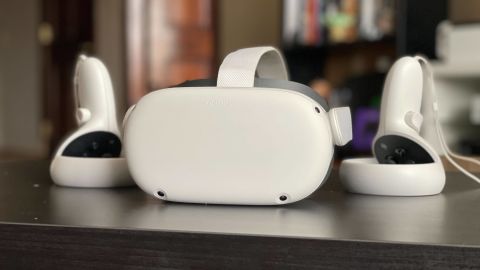 Óculos de realidade virtual Meta Quest 2 branco, com dois controles ao lado, sobre uma mesa escura