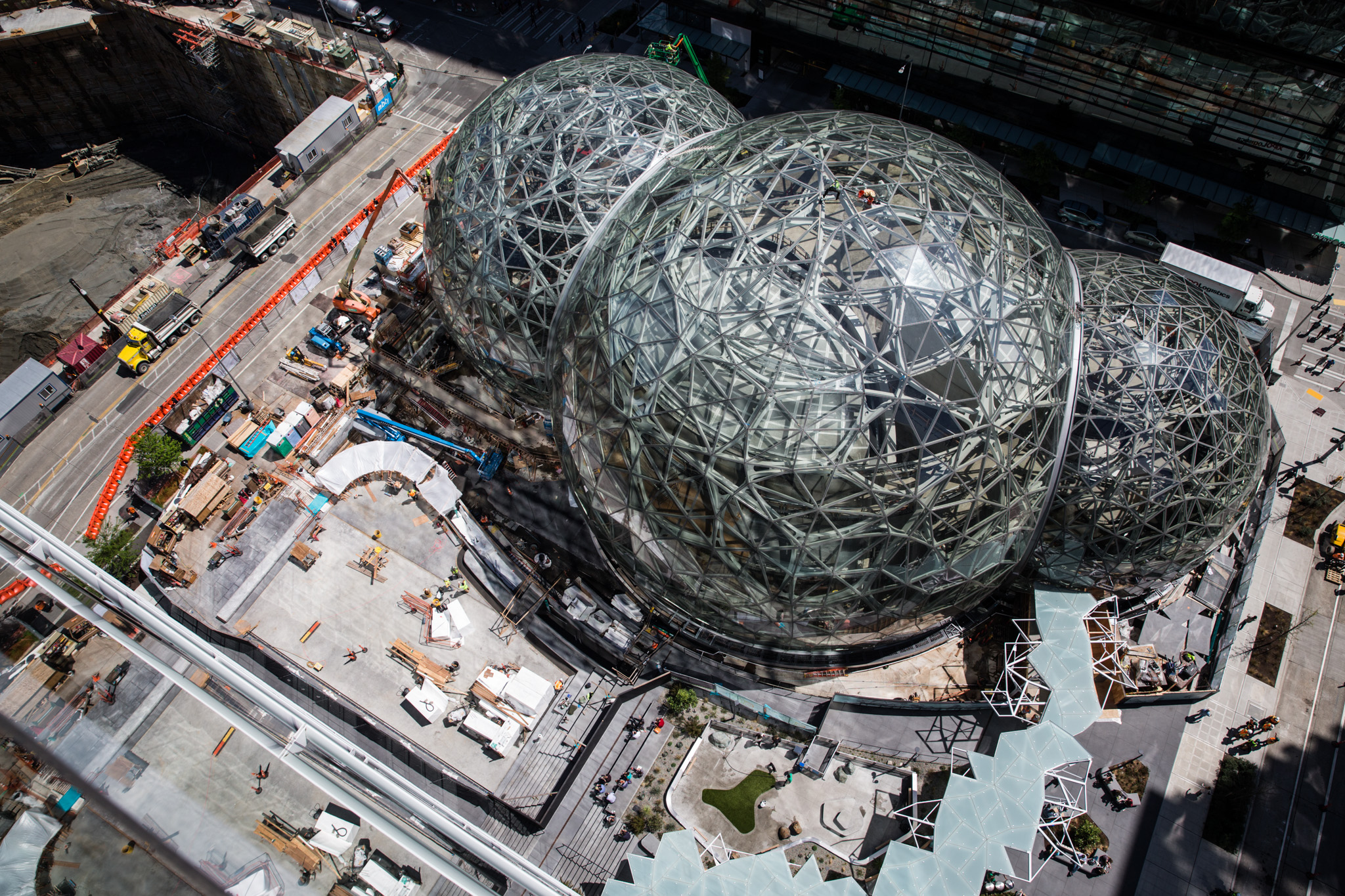 Vista aérea das esferas de vidro e aço da Amazon em construção no centro de Seattle, com guindastes e canteiro de obras ao redor