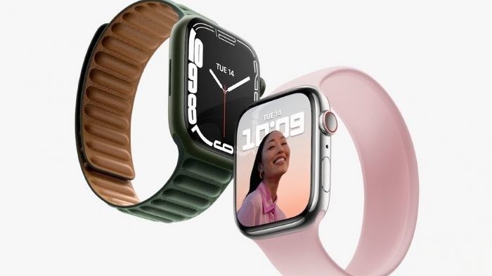Dois Apple Watch lado a lado: um com pulseira de loop verde-escuro e outro com pulseira rosa, exibindo o mostrador com a hora 10:09 e uma mulher sorrindo