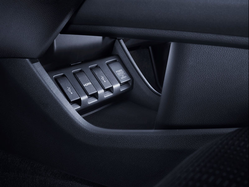 Painel interno de um veículo Honda com tomadas USB, uma entrada HDMI e uma saída de energia, instaladas no console central