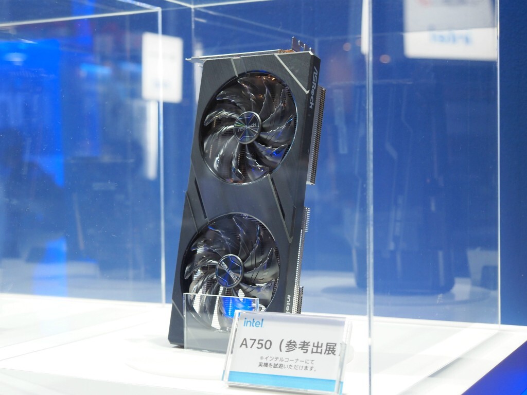 Placa de vídeo Intel Arc A750 com dois coolers exposta em vitrine de acrílico, com placa indicando modelo de exibição em japonês