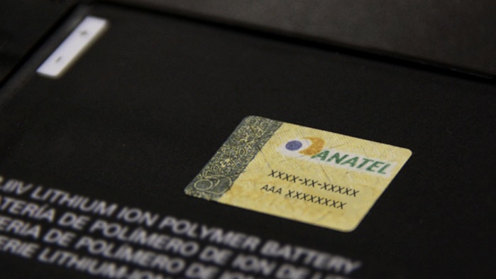 Selo da Anatel com código de homologação colado sobre a bateria de íon de lítio preta de um dispositivo eletrônico