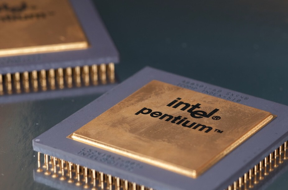 Processador Intel Pentium dourado com pinos dourados, em destaque sobre superfície escura, com outro chip ao fundo