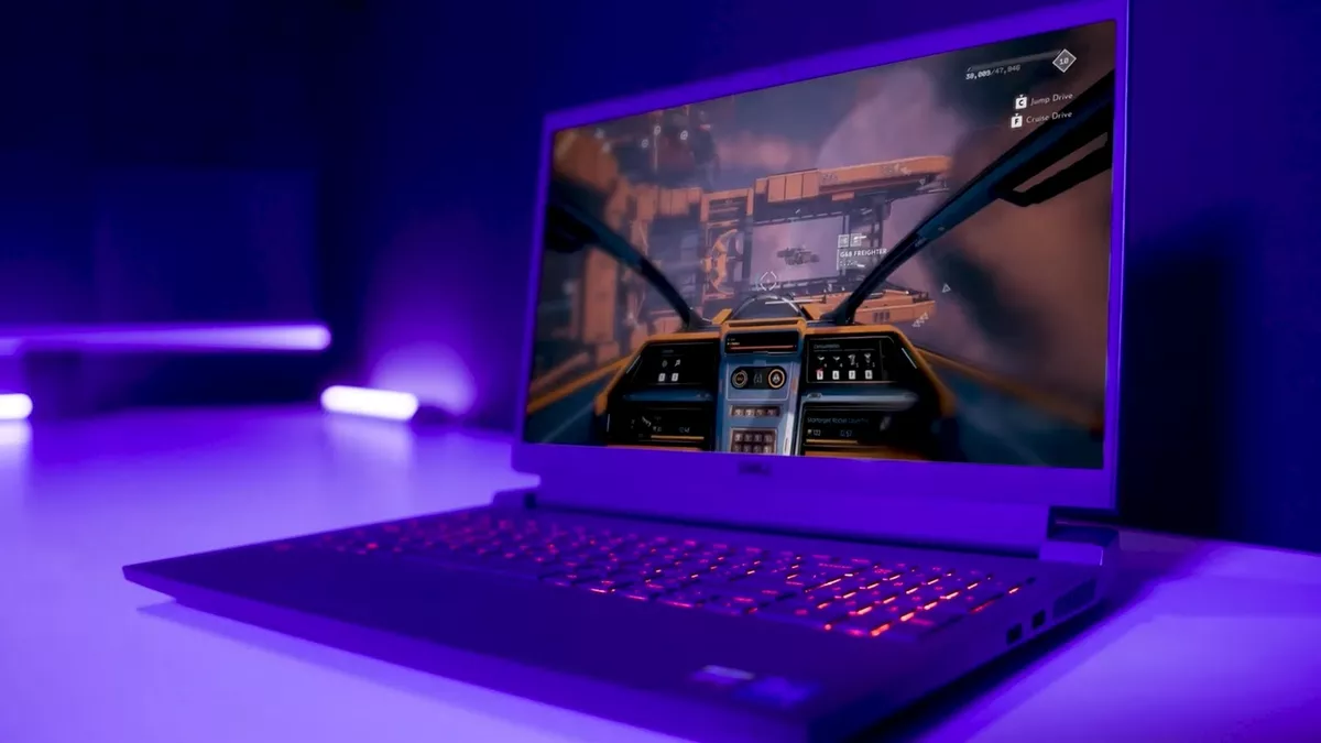 Notebook gamer com teclado iluminado em vermelho exibindo cena de jogo espacial em primeira pessoa sobre mesa com luz roxa