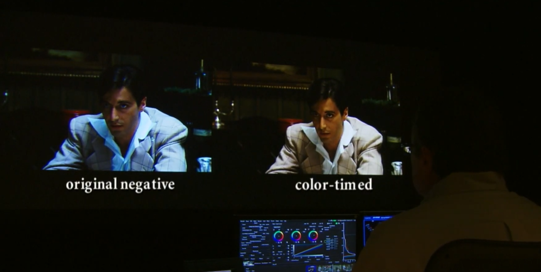 Comparação lado a lado de um homem de terno claro com legendas "original negative" e "color-timed", mostrada em tela de cinema durante a correção de cor da res…