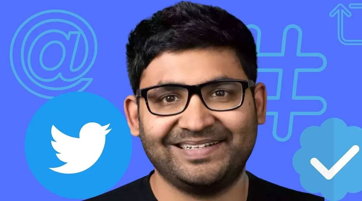 Homem sorrindo de óculos sobre fundo azul com logotipo do Twitter, símbolos de arroba, hashtag e selo de verificação