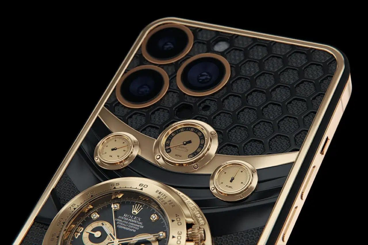 Traseira de iPhone 14 Pro Max dourada com acabamento em favo de mel preto e relógio Rolex Daytona de ouro embutido no aparelho