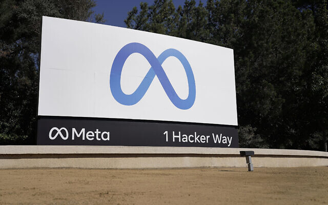 Placa da sede da Meta com o logotipo em azul e o endereço "1 Hacker Way", em Menlo Park, Califórnia