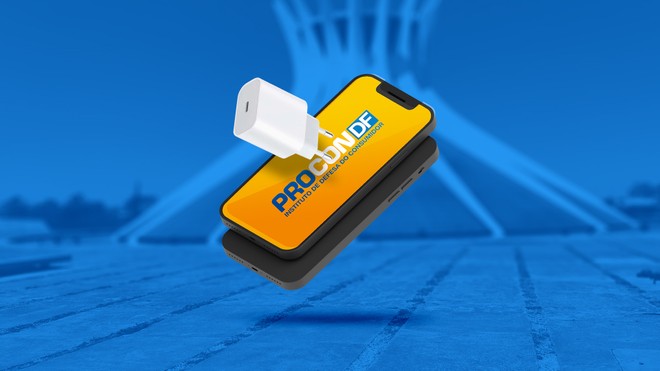Smartphone com a logo do Procon-DF na tela, ligado a um carregador branco, sobre fundo azul com a Catedral de Brasília ao fundo