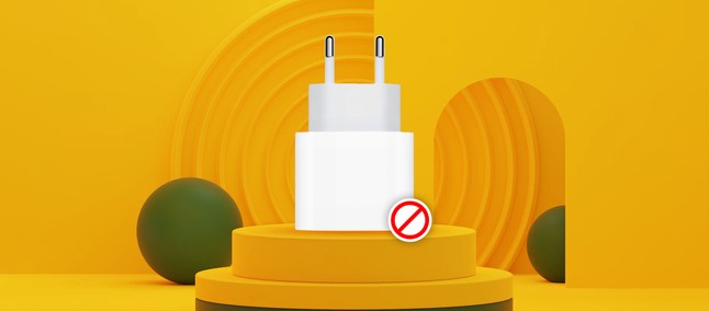 Carregador USB branco de parede com símbolo de proibição sobre pedestal amarelo, em cenário 3D, ilustrando venda sem carregador
