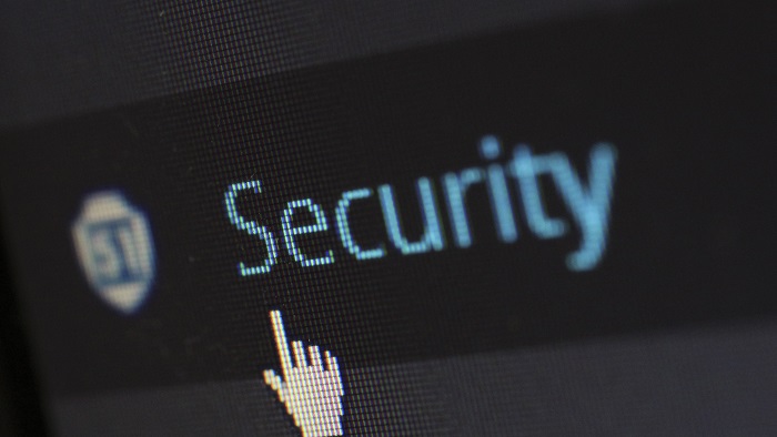 Tela escura de computador exibindo a palavra "Security" em azul, com um ícone de escudo à esquerda e um cursor de mão apontando para o texto