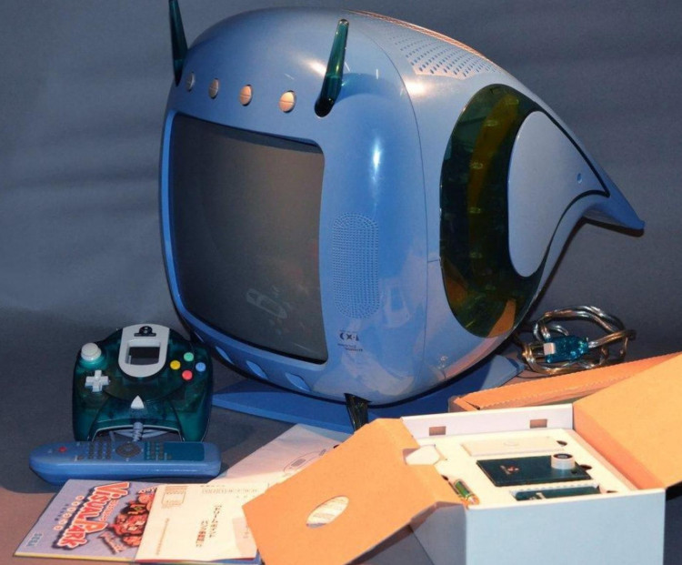 TV azul Sega Dreamcast Dives 2000 CX-1 com controle transparente verde, controle remoto, manual de Virtua Fighter e caixa aberta com o console embutido