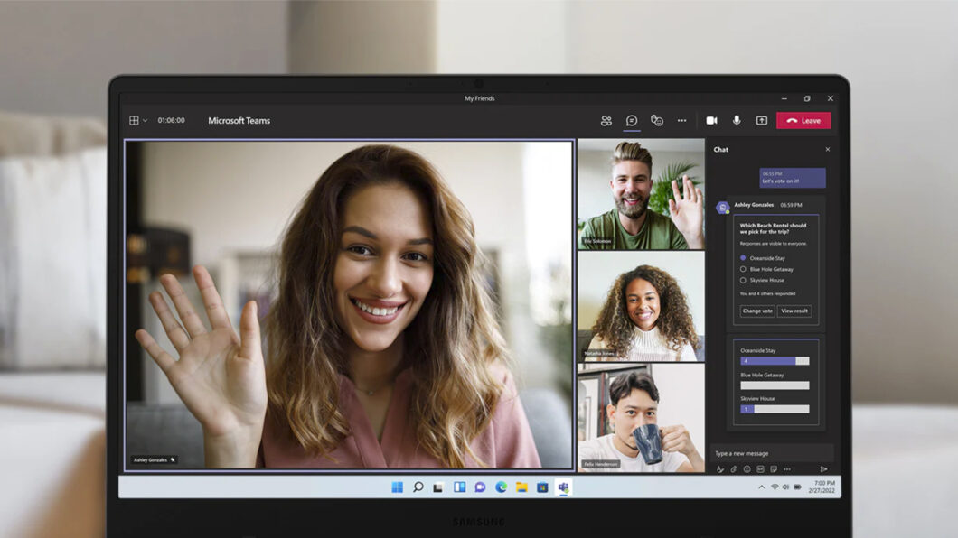 Notebook Samsung exibindo chamada de vídeo no Microsoft Teams com quatro participantes, uma mulher acenando e um chat com votação na lateral direita